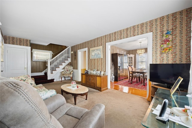 carpeted living room featuring a notable chandelier