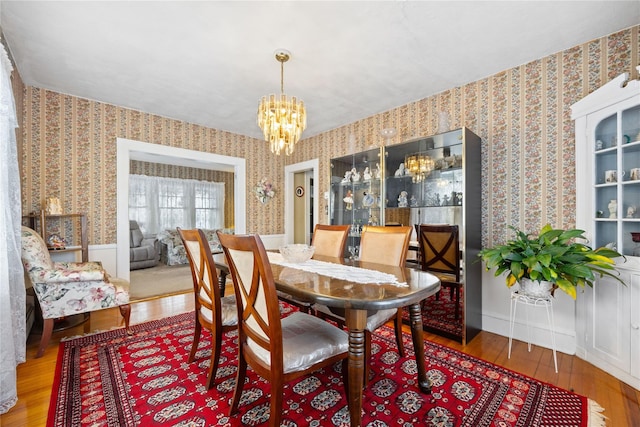 dining area with hardwood / wood-style flooring and an inviting chandelier