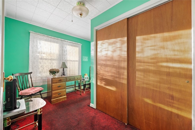 office space with dark colored carpet and a baseboard heating unit