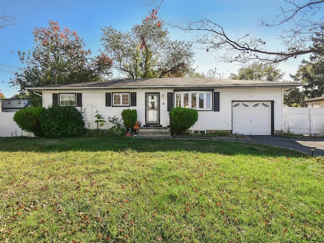 ranch-style house featuring a front yard, fence, a garage, and aphalt driveway