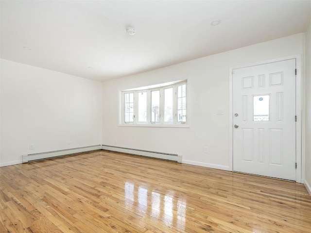 foyer featuring a baseboard heating unit, light wood-style flooring, and baseboards