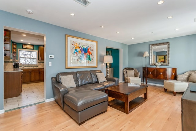 living room with sink and light wood-type flooring