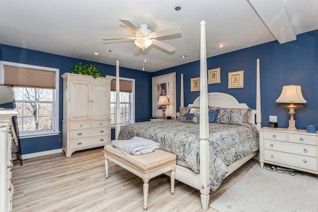 bedroom featuring multiple windows, light hardwood / wood-style floors, and ceiling fan