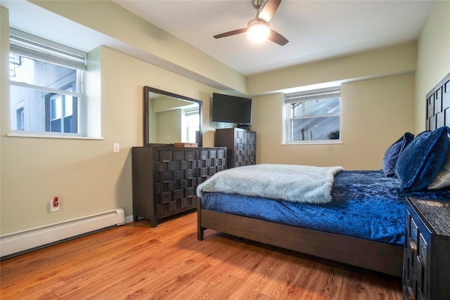 bedroom featuring ceiling fan, a baseboard heating unit, and hardwood / wood-style floors