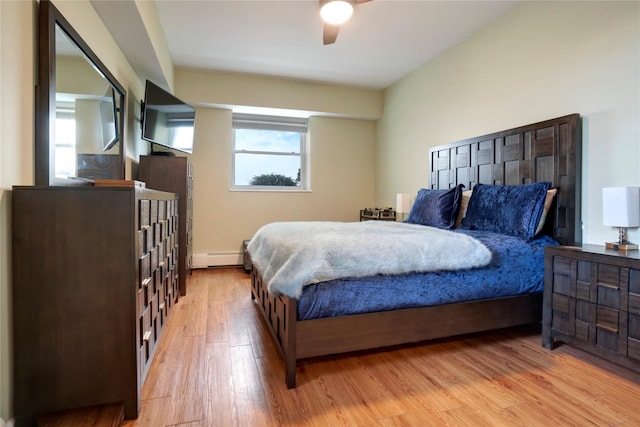 bedroom featuring ceiling fan, a baseboard radiator, and light hardwood / wood-style flooring