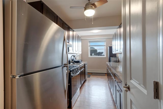 kitchen with light stone countertops, stainless steel refrigerator, sink, dark brown cabinetry, and range with gas cooktop