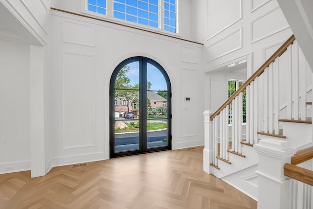85 Dorchester Dr, Manhasset, NY 11030 - foyer entrance featuring a decorative wall, a high ceiling, stairway, and arched walkways