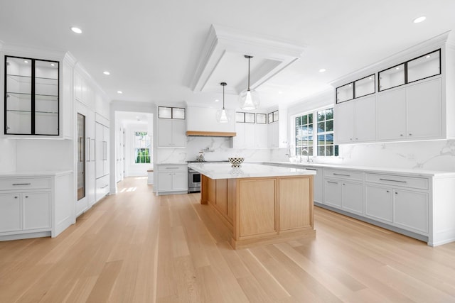 85 Dorchester Dr, Manhasset, NY 11030 - kitchen featuring light wood-style floors, a center island, decorative backsplash, glass insert cabinets, and recessed lighting