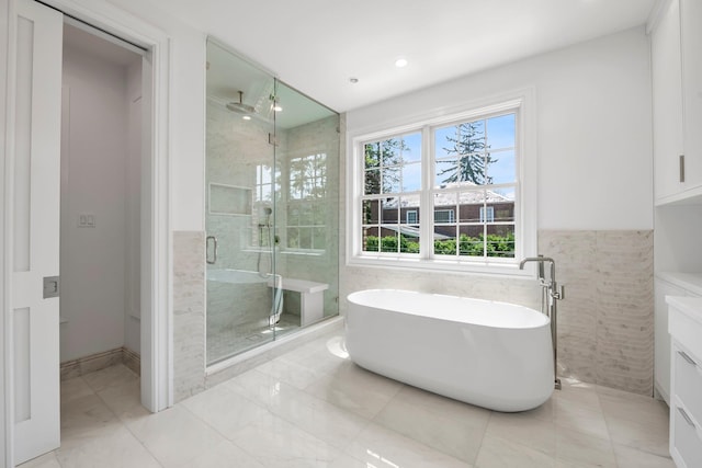 85 Dorchester Dr, Manhasset, NY 11030 - bathroom featuring a stall shower, a freestanding tub, tile walls, and recessed lighting
