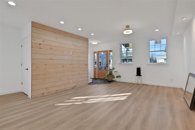 interior space featuring light hardwood / wood-style flooring and wooden walls