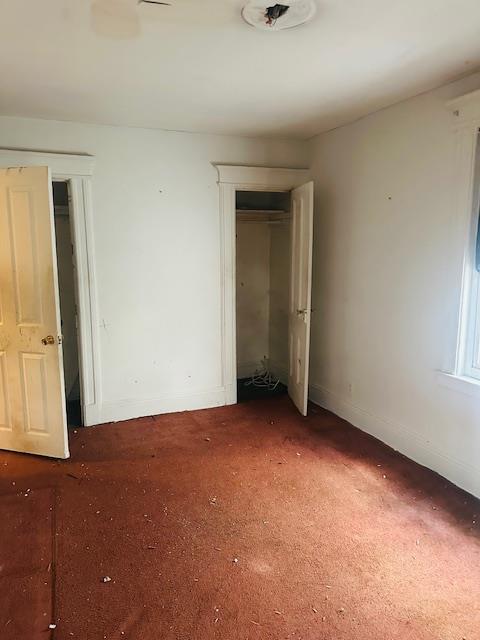 unfurnished bedroom featuring dark colored carpet