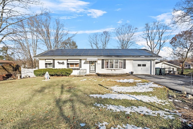 view of front of house with a garage, a front lawn, and solar panels