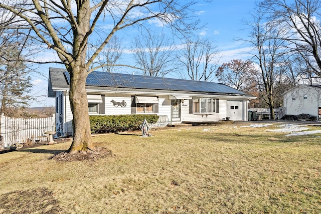 view of front of property with a front yard and solar panels