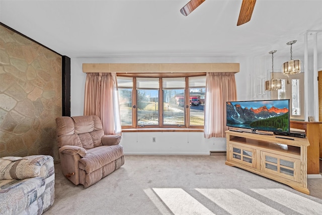 carpeted living room with ceiling fan with notable chandelier