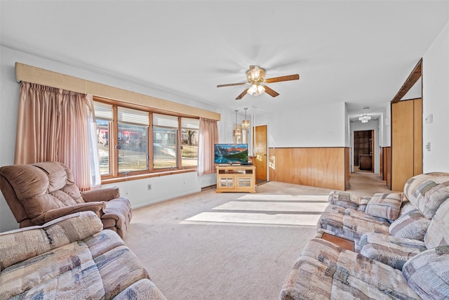 living room with light carpet, wood walls, and ceiling fan