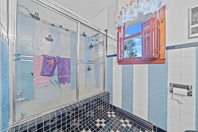 bathroom featuring a shower with shower door and tile walls