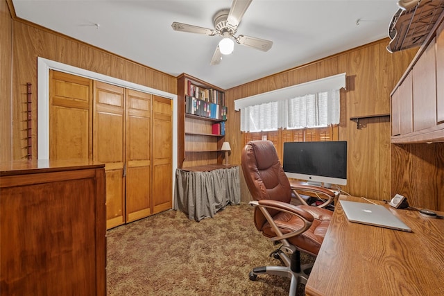 office area with light carpet, wooden walls, and ceiling fan