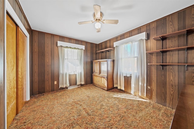 interior space with multiple windows, carpet floors, a closet, and ceiling fan