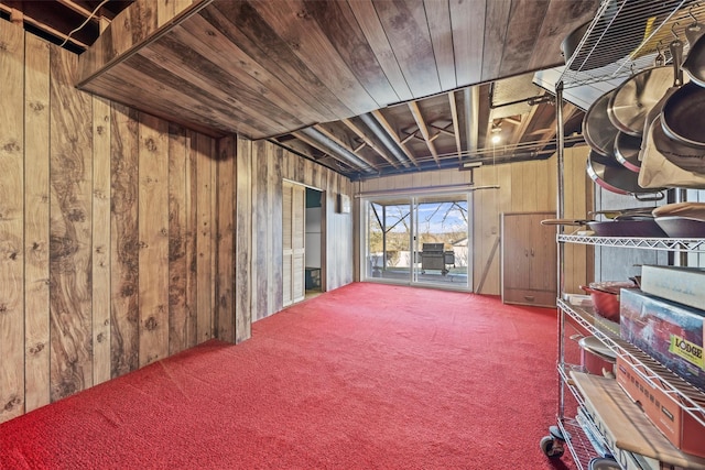 basement featuring wooden ceiling, wooden walls, and carpet