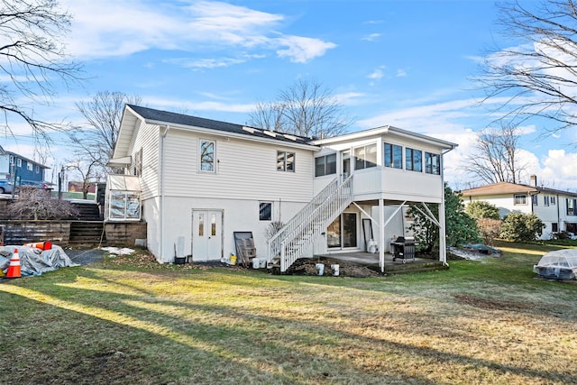 back of property featuring a patio area, a yard, and a sunroom