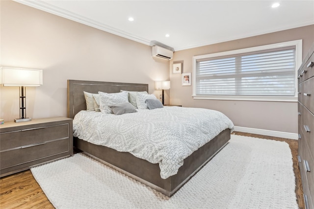 bedroom with hardwood / wood-style flooring, ornamental molding, and a wall mounted AC