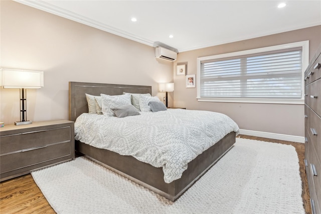 bedroom featuring a wall unit AC, wood finished floors, crown molding, recessed lighting, and baseboards