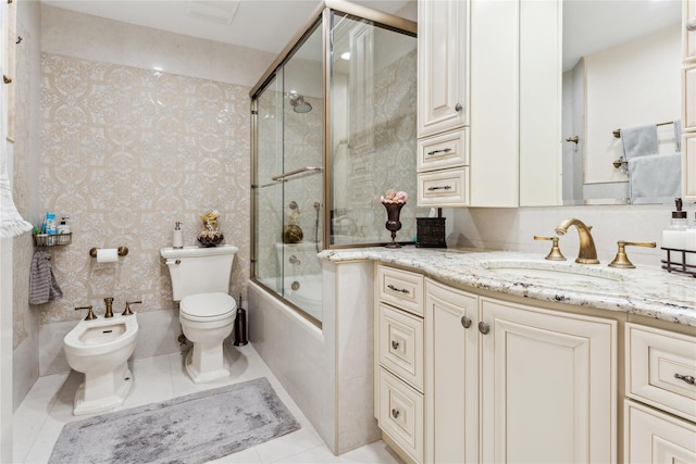 bathroom with toilet, vanity, a bidet, shower / bath combination with glass door, and tile patterned floors