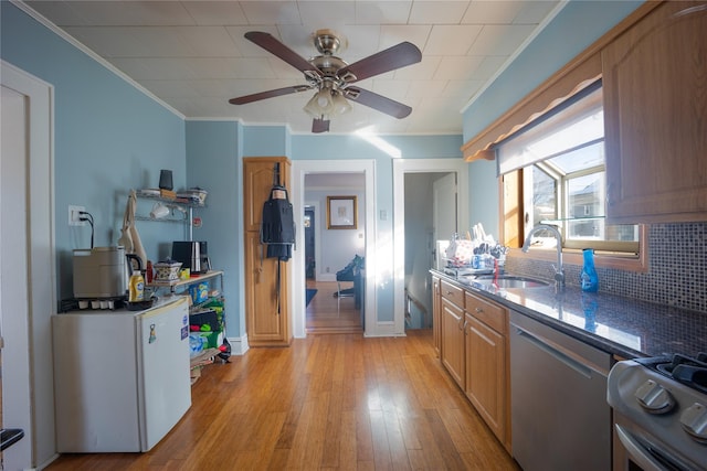 kitchen featuring crown molding, light hardwood / wood-style floors, light brown cabinetry, sink, and stainless steel appliances