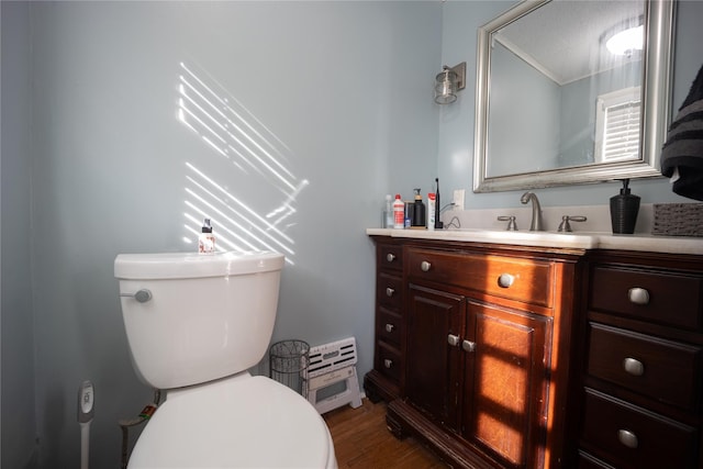 bathroom with vanity, toilet, and hardwood / wood-style floors