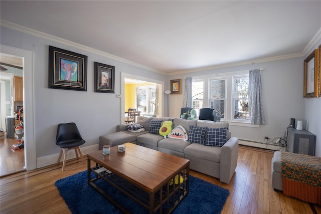 living room featuring a baseboard heating unit, hardwood / wood-style floors, and crown molding