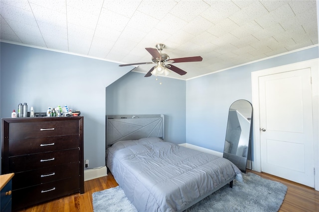 bedroom with ceiling fan, dark hardwood / wood-style floors, and ornamental molding