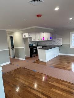 kitchen with range, white cabinetry, dark hardwood / wood-style floors, kitchen peninsula, and crown molding