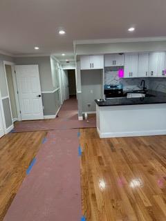 kitchen featuring crown molding, light hardwood / wood-style floors, white cabinets, sink, and backsplash