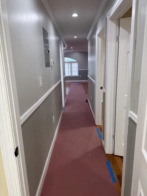 hall with dark carpet and crown molding