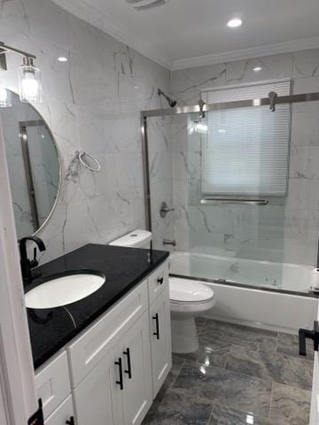 full bathroom with vanity, bath / shower combo with glass door, toilet, tile walls, and ornamental molding