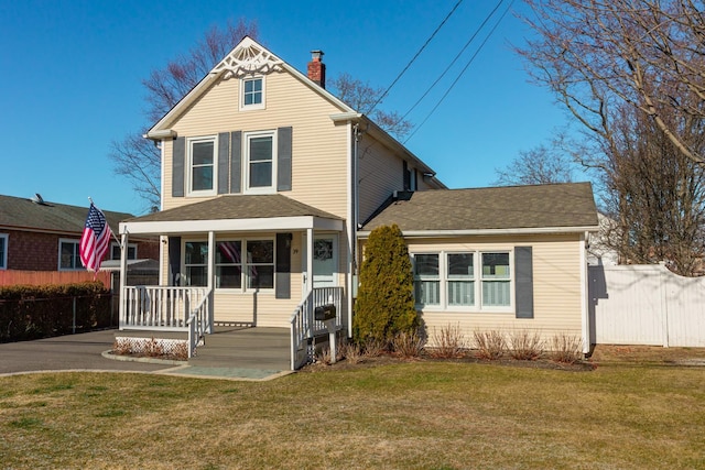 view of front of home with covered porch and a front lawn