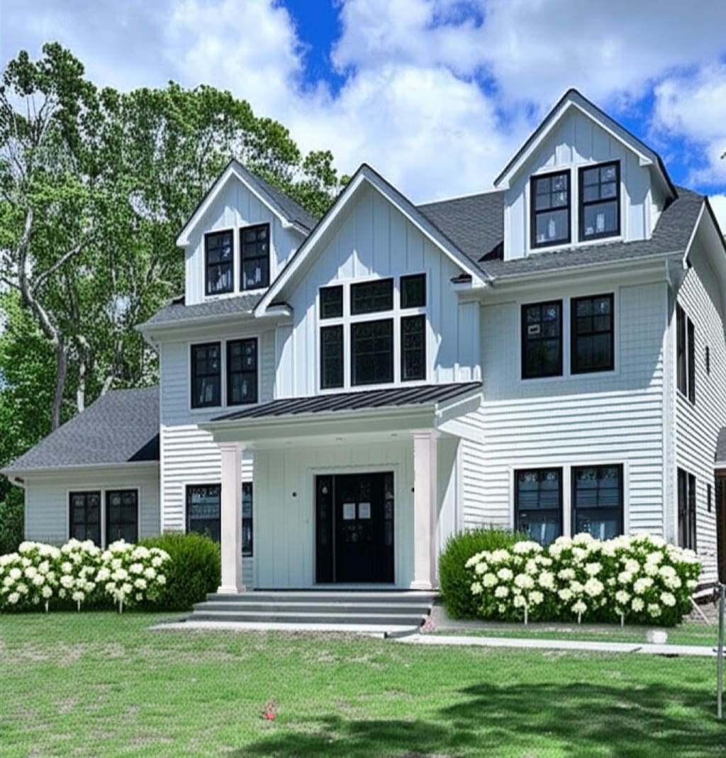 16 Hampton St, Westhampton Beach, NY 11978 - modern farmhouse style home featuring a front lawn, board and batten siding, and covered porch
