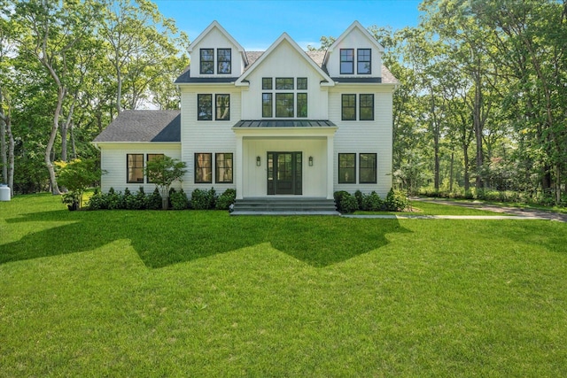 16 Hampton St, Westhampton Beach, NY 11978 - view of front of property featuring a standing seam roof, a front yard, a metal roof, and a shingled roof
