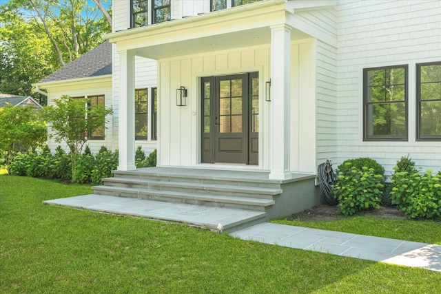 16 Hampton St, Westhampton Beach, NY 11978 - doorway to property with board and batten siding and a lawn