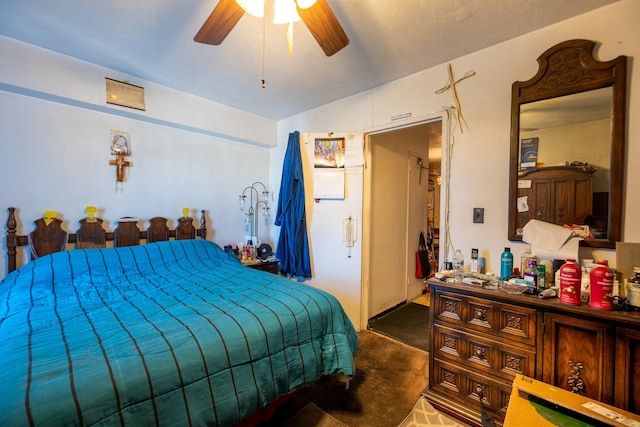 bedroom with dark colored carpet, a textured ceiling, and ceiling fan