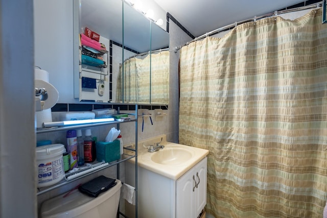 bathroom with vanity, toilet, and tile walls