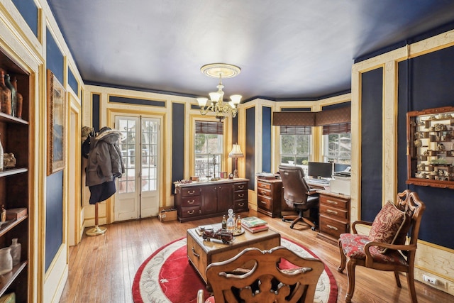 office featuring crown molding, a chandelier, and light wood-type flooring