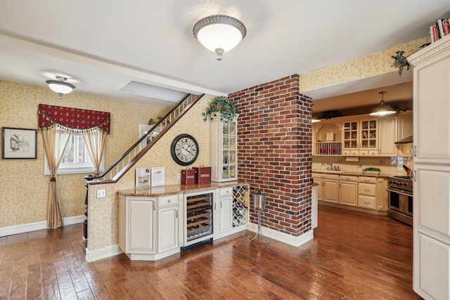 kitchen with wine cooler, hanging light fixtures, double oven range, light stone countertops, and dark wood-type flooring