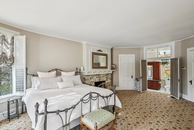 bedroom with ornamental molding, a brick fireplace, and connected bathroom