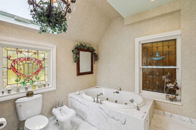 bathroom with tiled tub, a bidet, and toilet