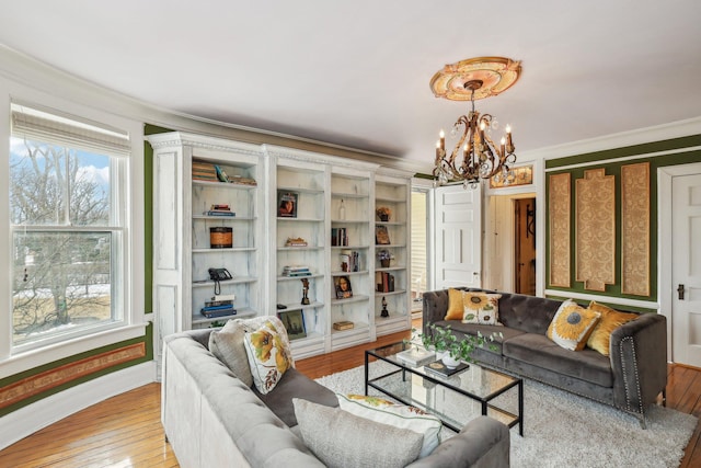 living room featuring ornamental molding, a chandelier, and light wood-type flooring