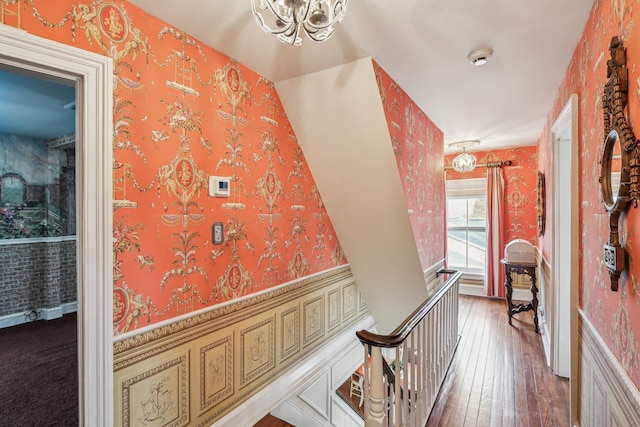 hall with hardwood / wood-style floors and a chandelier