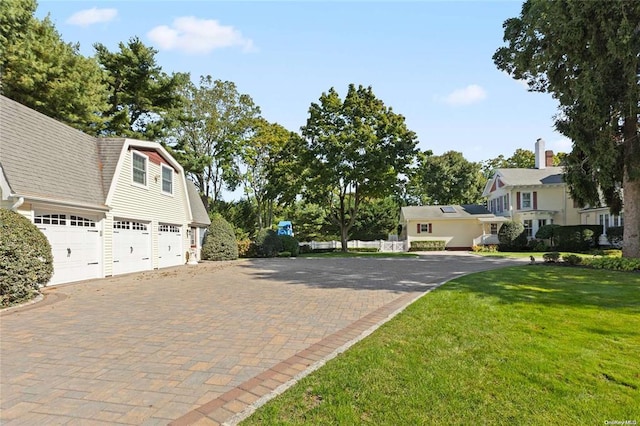 view of property exterior featuring a gambrel roof, driveway, a garage, and a yard