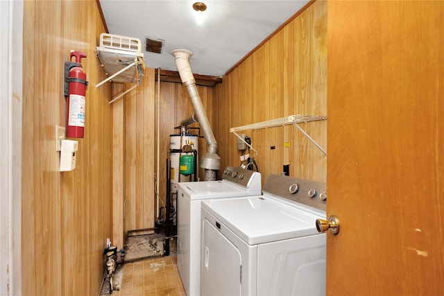 washroom with washer and dryer and wooden walls