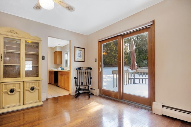 doorway to outside with ceiling fan, light hardwood / wood-style flooring, and a baseboard radiator